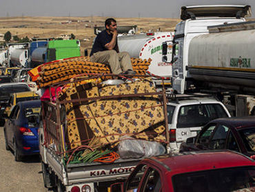 People leaving areas controlled by the Islamic State in Iraq and Syria wait to clear the Khazer checkpoint between Mosul and Erbil in Iraq, June 14, 2014. A rebel juggernaut that captured Iraq's second-largest city and raced south in three days, raising fears of the imminent fall of Baghdad, stalled for a second day on Saturday about 60 miles north of the capital, leaving residents bracing for a siege that so far has not happened. (Bryan Denton/The New York Times)