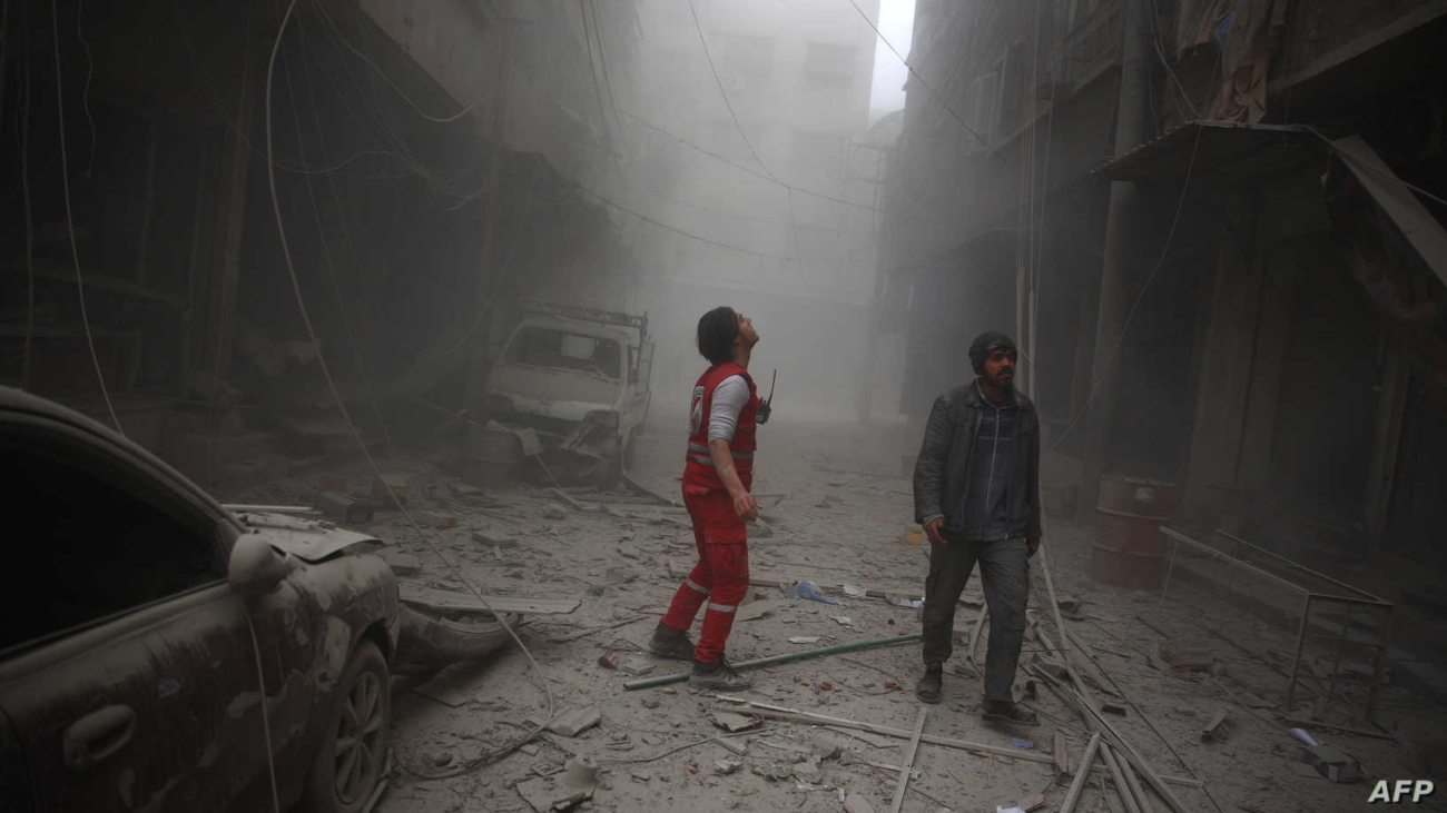 A member of the Syrian Arab Red Crescent looks for survivors in a street covered with dust following air strikes in the rebel-held town of Douma, on the eastern edges of the Syrian capital Damascus, on December 13, 2015. The Syrian Observatory for Human Rights said rockets fired by regime forces rained down on Douma, one of the largest towns in the opposition-held Eastern Ghouta region. AFP PHOTO / ABD DOUMANY (Photo by ABD DOUMANY / AFP)