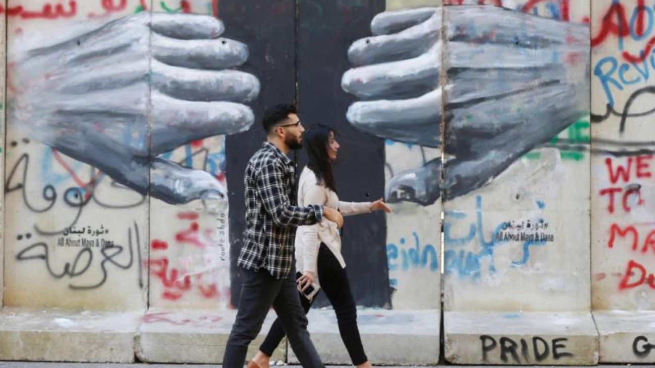 People-walk-past-a-mural-painted-by-Lebanese-artist-Roula-Abdo-in-downtown-Beirut-Lebanon-February-6-2020.-REUTERS