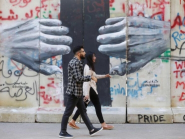 People-walk-past-a-mural-painted-by-Lebanese-artist-Roula-Abdo-in-downtown-Beirut-Lebanon-February-6-2020.-REUTERS